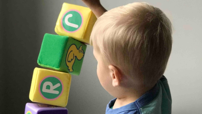 Child playing with some cubes with letters