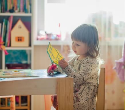 little girl cutting out a drawing